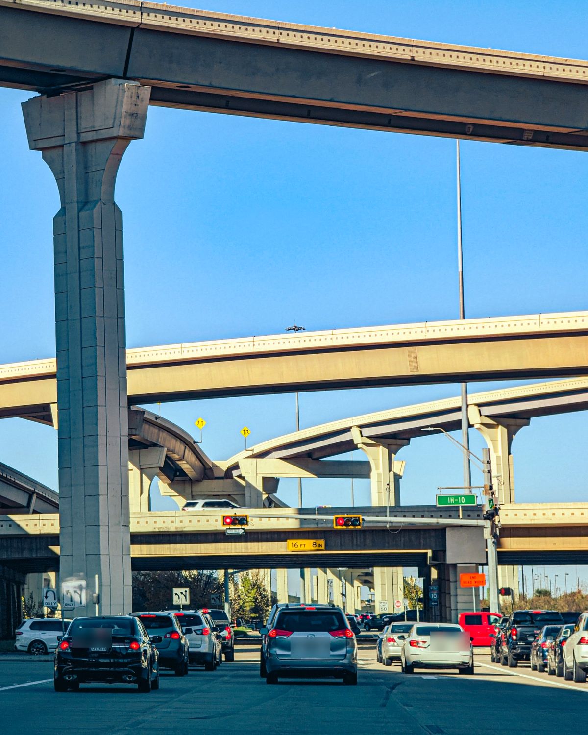 Traffic under the tall ramps of a Houston freeway interchange